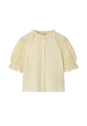 Blouse courte jaune pâle à manches courtes, avec des boutons sur le devant et une broderie florale en broderie anglaise sur les manches bouffantes et les bords festonnés.