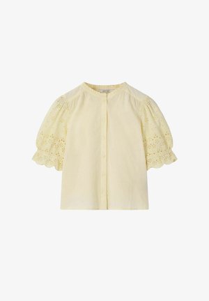 Blouse courte jaune pâle à manches courtes, avec des boutons sur le devant et une broderie florale en broderie anglaise sur les manches bouffantes et les bords festonnés.
