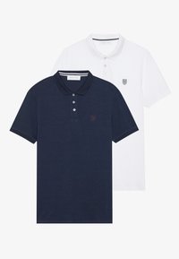 Camisas polo en tono navy y blancas, de manga corta, fabricadas en algodón, con botonera, cuello y logotipo bordado en el pecho.