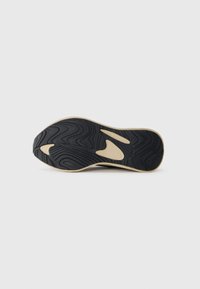 Black rubber shoe sole with a wavy texture, featuring a light-colored midsole and cutouts for flexibility. Smooth finish.