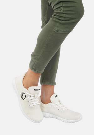 Helle beige Canvas-Sneaker mit weißen Gummisohlen. Zu den Merkmalen gehören eine runde Zehenpartie, ein Schnürdesign und ein Logo an der Seite.