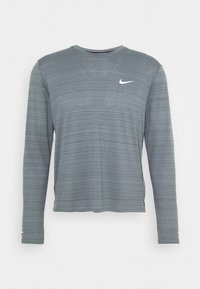 Langärmliges graues Nike-Shirt mit einem strukturierten Streifenmuster und einem weißen Logo auf der Brust. Hergestellt aus leichtem, atmungsaktivem Material.