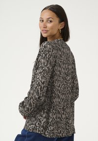 T-shirt à manches longues avec un motif imprimé animal gris et noir, présentant une coupe décontractée et un tissu doux au toucher.