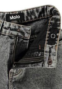 Svarte slitt denimjeans med glidelås, knappestengning, kontrastsømmer og et Molo-merke på midjen.