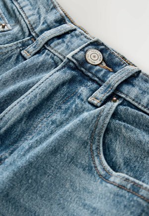 Ljust blå denimjeans med en sliten textur, med en silverknapp och subtila orange sömmar längs sömmarna och fickorna.