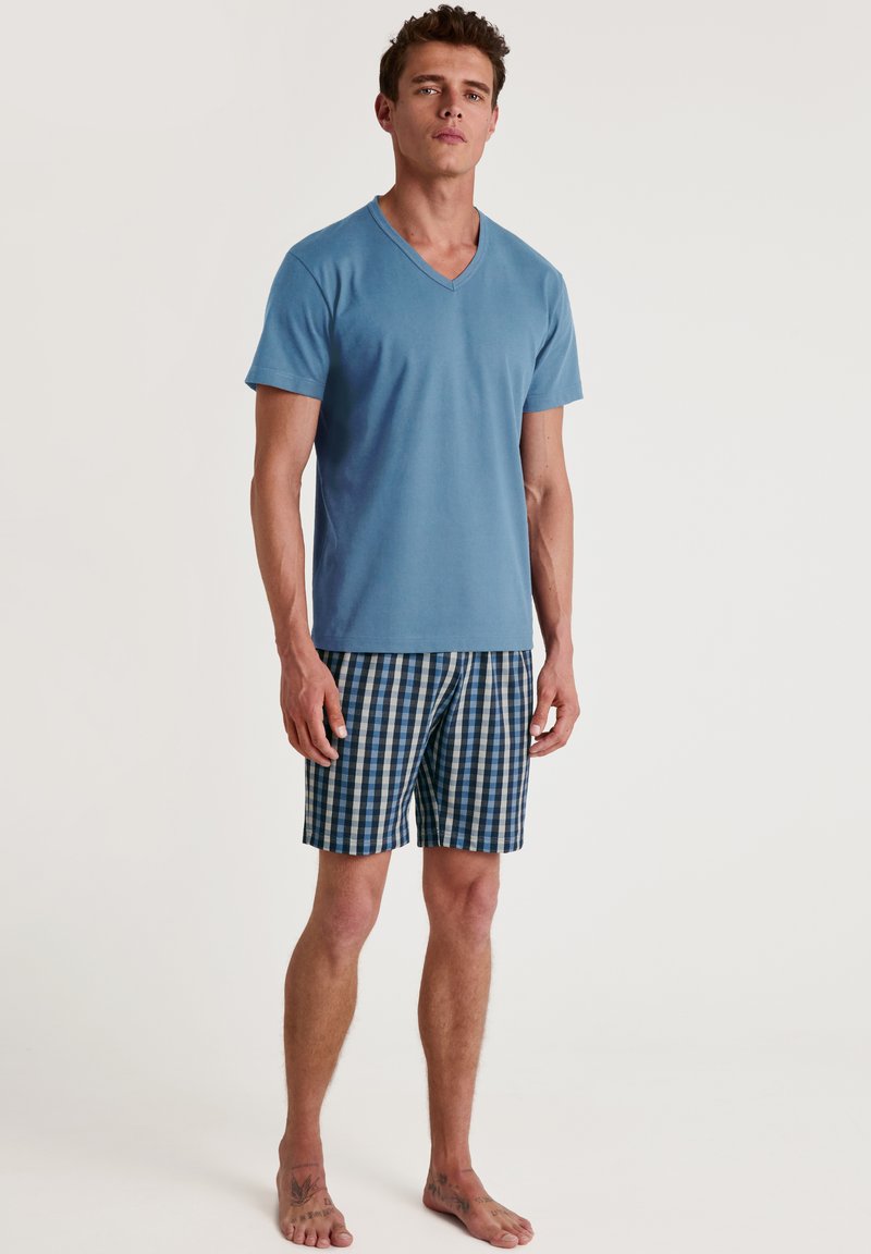 Light blue cotton t-shirt with a V-neck, paired with blue and white checkered shorts. The shorts feature an elastic waistband and side pockets.
