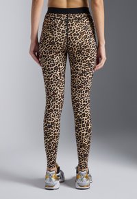 Leggings sa uzorkom leoparda, izrađene od rastezljivog materijala s visokim strukom, s glatkom završnom obradom i crnim akcentima na vrhu.