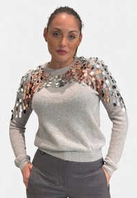 Maglione grigio a maniche lunghe, decorato con paillettes circolari metalliche in rame, argento e nero. Texture morbida, scollo rotondo.