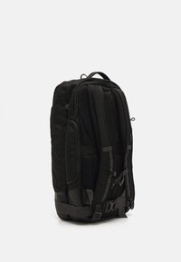 Sac à dos noir en tissu durable, dos rembourré, bretelles réglables, poches latérales et accents en métal. Design compact et structuré.