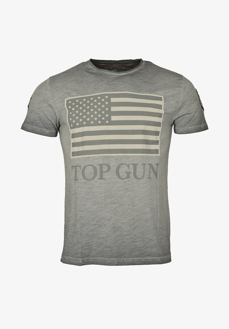Harmaa t-paita pehmeästä kankaasta, jossa on suuri, haalistunut Amerikan lippu -graafikka ja "TOP GUN" -teksti rohkeassa, kontrastivärissä.