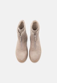 Stivali alla caviglia beige in suede con doppia zip, fodera morbida, suola in gomma testurizzata e punta arrotondata.