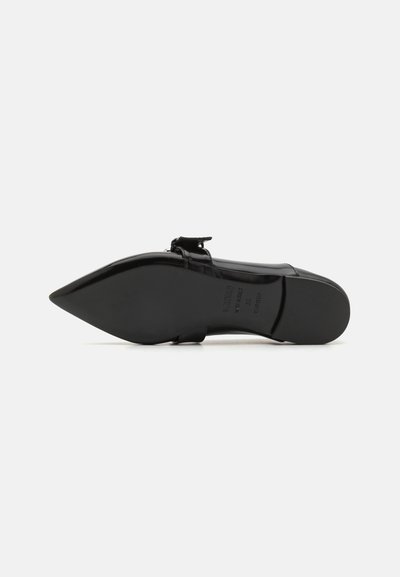 Black patent leather flat shoe with a pointed toe, ankle strap, and subtle heel. Smooth texture and minimalistic design accents.