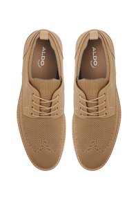 Zapatos lace-up beige con parte superior de punto texturizado, costuras en contraste y suelas de goma; incluye marca en el forro interior.