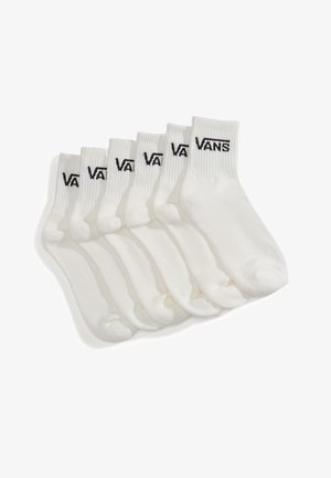 Seis pares de calcetines blancos tipo crew con el logo negro de Vans en los puños acanalados, dispuestos uno al lado del otro sobre un fondo blanco.