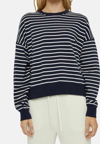 Sweat-shirt rayé bleu marine et blanc avec un col rond, des épaules tombantes, des poignets et un ourlet côtelés. Tissu doux avec une coupe décontractée.