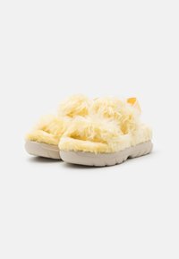 Yellow fuzzy slide sandals with a thick sole, featuring a soft texture and an adjustable back strap, suitable for casual wear.