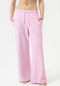 Roze sweatpants met een ontspannen pasvorm, trekkoord in de taille en zijzakken. Gemaakt van zachte stof met een gladde textuur, met een eenvoudig ontwerp.