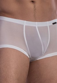 Boxer slim bianchi, a coste, con una cintura morbida e un design aderente, che mostrano una texture di tessuto trasparente e un discreto dettaglio di branding.
