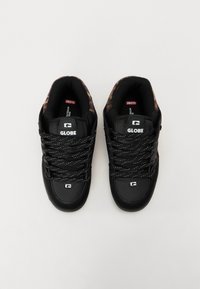 Black sneakers with a textured finish, featuring prominent white branding, black laces with blue accents, and a leopard print inner lining.