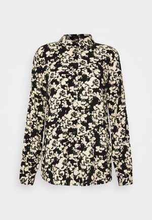 Zwart overhemd met lange mouwen en knopen, beige bloemmotief en puntige kraag, afgebeeld op een effen lichtgrijze achtergrond.