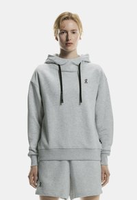 Gray sweatshirt with a hood and black drawstrings. Features a logo on the chest and is paired with matching gray shorts. Soft texture.