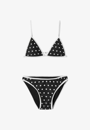 Musta bikini, jossa valkoisia polkkapilkkuja, kolmionmuotoinen yläosa ohuilla olkaimilla ja matalavyötäröiset alaosat, joissa valkoiset reunukset.