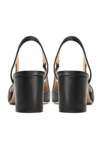 Sandali in pelle nera con tacco a blocco e apertura sul retro, caratterizzati da un design curvo e una soletta nuda. Texture liscia e chiusura con semplice fibbia.