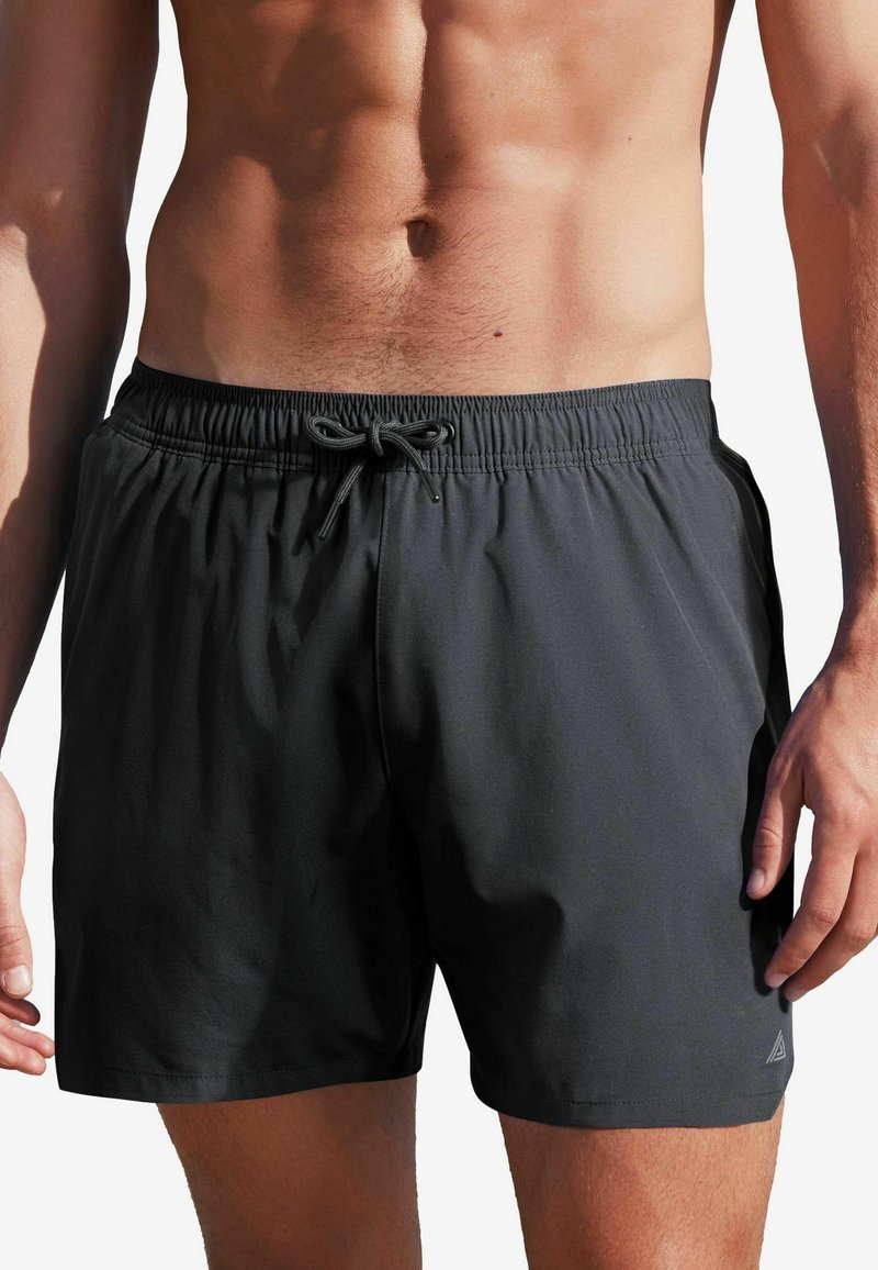 Schwarze Badeshorts mit elastischem Bund und Kordelzug. Hergestellt aus leichtem Material, mit Seitentaschen und kleinem Logo am Saum.