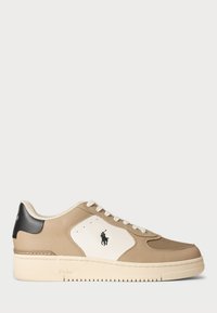 Beige och vit låg sneaker med vita snören, svart hälflik och svart Polo-logotyp på sidopanelen samt "Polo" präglat på sulan.