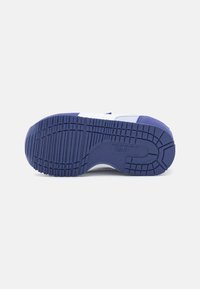Semelle de sneaker bleu et blanc avec une surface en caoutchouc texturé ; présente un design de semelle à motifs pour l'adhérence et la durabilité.