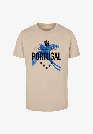 Beige pamut póló, kék madár grafikával, koronával és vastag betűvel írt "PORTUGAL" szöveggel, alatta pedig hat kis pajzs ikon található.
