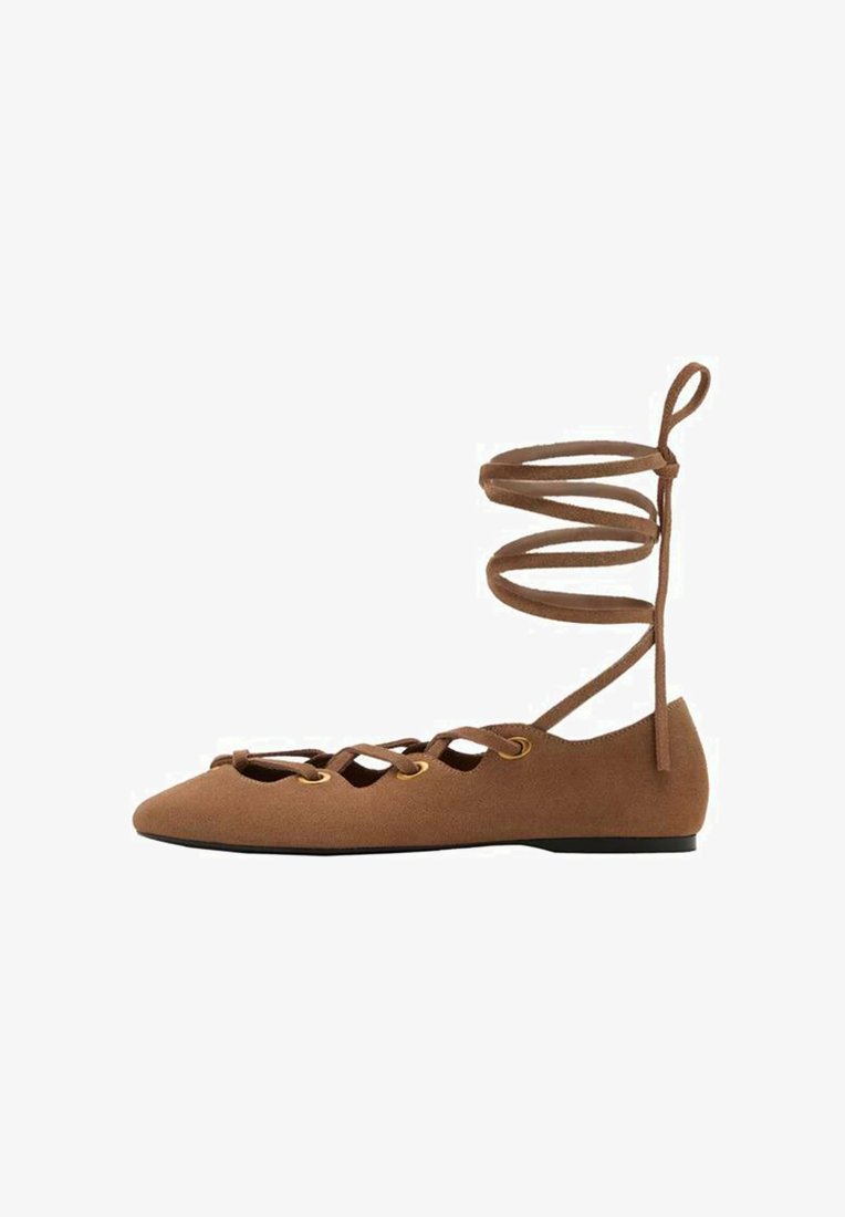 Muutamat ruskeat mokka-ballet-kengät, joissa on terävä kärki, leikattu muotoilu ja ristikkäin menevät hihnat. Varustettu kultasävyisillä aukkoilla ja littealla pohjalla.