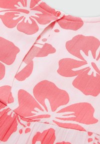 Rosa Blumenkleid mit großen Hibiskus-Mustern auf einem hellrosa Hintergrund. Verfügt über einen Knopfverschluss und eine plissierte Textur am Saum.