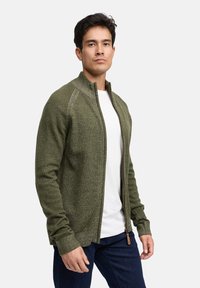 Olijfgroene trui met ritssluiting, hoge kraag, geribde manchetten en zoom, gemaakt van gestructureerde gebreide stof met een subtiele glans.