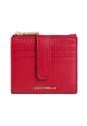 Portefeuille en cuir rouge texturé avec une fermeture éclair dorée, des emplacements pour cartes et une sangle avant, marqué de la marque "Coccinelle" en lettres dorées.