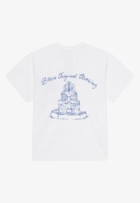 Balta kokvilnas T-kreklu ar zilu grafiku, kurā attēlots kārtu kūka ar dekoratīviem akcentiem un teksts "Bklvrs Original Clothing" virs dizaina.