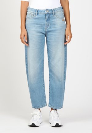 Light blue straight-leg jeans with five pockets, faded wash, and subtle stitching details. Paired with white athletic shoes.
