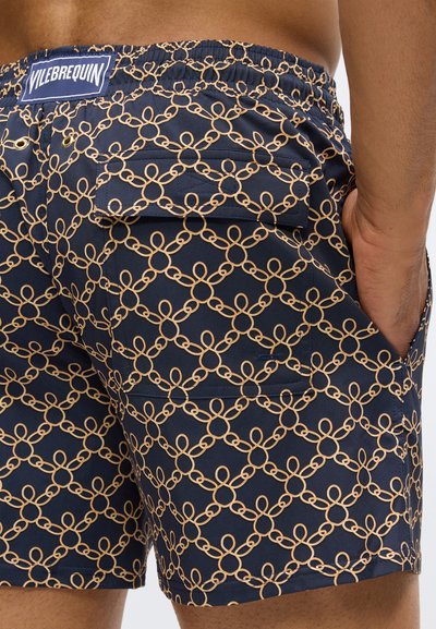 Jūras kara flote peldēšanas šorti ar bežīgu ķēdes rakstu, elastīga josta, aizmugurējais kabatas pārklājs, sānu kabata ar roku ievietotu.