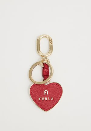 Crvena kožna privjesak u obliku srca s utisnutim logotipom "FURLA" i zlatnim detaljima, koji sadrži privjesak za ključeve i teksturiranu površinu.