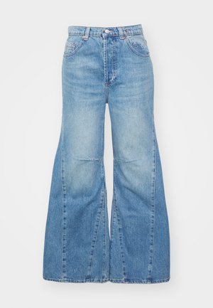 Jeanși de culoare albastru deschis, cu croială largă și talie înaltă. Prezintă închidere cu fermoar și nasture, cinci buzunare și o textură de denim decolorat.