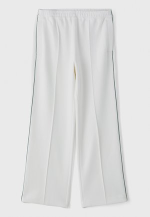 Pantalons larges blancs avec une taille élastique, dotés de poches latérales et d'un passepoil vert contrastant sur les côtés. Texture de tissu lisse.