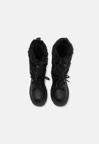 Black winter boots with a faux fur upper, padded collar, rubber sole, adjustable lace-up closure, and a rounded toe design.
