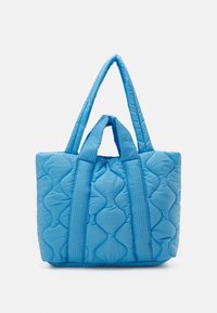 Geveste blauwe tote bag met twee lange handvaten en een korter handvat, met een gestructureerd golfpatroon op het oppervlak.