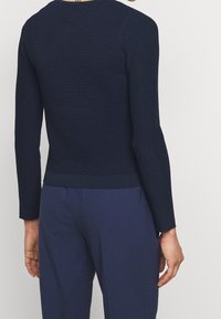 Granatowy, prążkowany top z długim rękawem, o dopasowanym kroju i okrągłym dekolcie, z teksturowanej tkaniny oraz jednolitą, kontrastową talią.