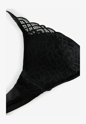 Melna mežģīņu krūšturis ar viļņotām malām, kas izceļas ar greznām mežģīņu detaļām un gludu audumu. Dizains ir kontūrēts ar mīkstu tekstūru.