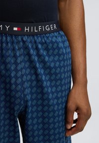 Μπλε παντελόνι πιτζάμας με σχέδιο υφαντό, με ελαστική μέση που φέρει το λογότυπο "Tommy Hilfiger" σε λευκό. Μαλακή υφή υφάσματος.