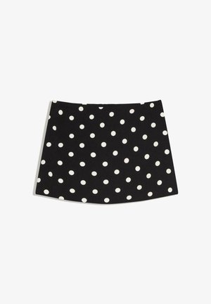 Schwarzer Minirock mit gleichmäßig verteilten großen weißen Punkten, gerader Schnitt, ohne sichtbare Verschlüsse oder Verzierungen.