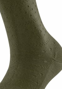 Chaussette vert olive en matériau texturé, arborant un motif à pois subtil pour une touche de détail et d'intérêt visuel supplémentaire.