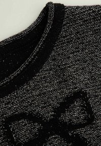 Czarny dziany sweter z fakturowanym srebnym splotem, okrągłym dekoltem i wyraźnym czarnym logo na przodzie.