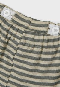 Şorturi dintr-un material tricotat cu dungi, de culoare bej deschis și verde închis, având un sistem de închidere cu nasturi la talie și o textură ribbed.